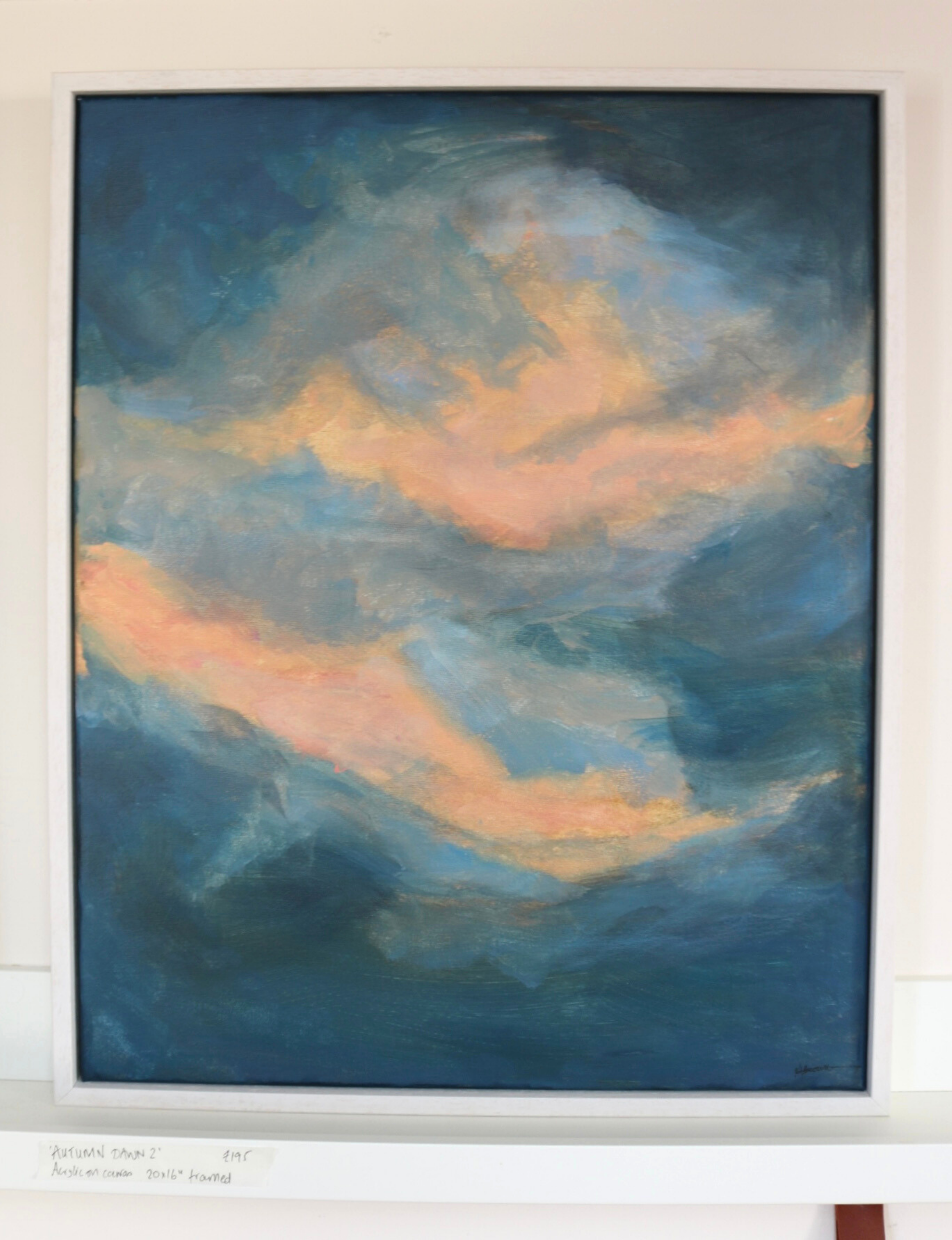 Autumn Dawn 2 painting is shown within its white wooden frame sat on a white wooden shelf.